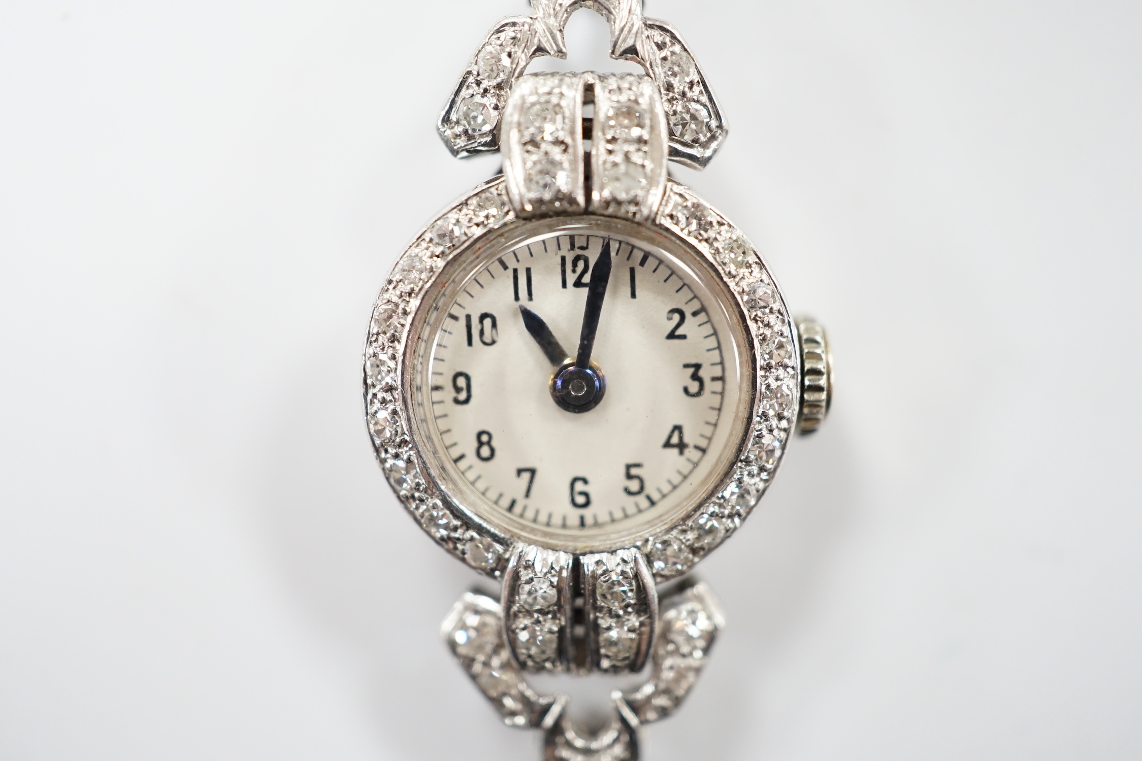 A mid 20th century white metal (inscribed platinum) and diamond cluster set Albion manual wind cocktail watch, no strap, gross weight 10 grams.
